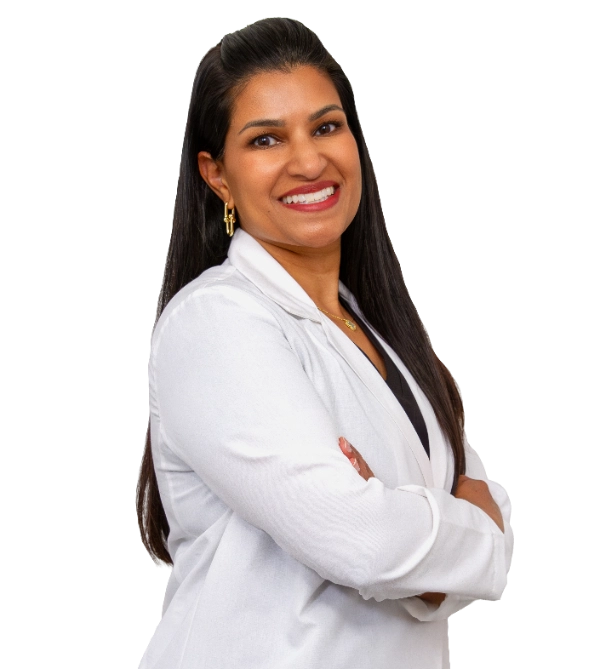 Professional headshot of Dr. Neetha Vilasagar wearing a white lab coat, smiling at the camera against a black background. This is a standard medical professional portrait used for clinic or practice identification.